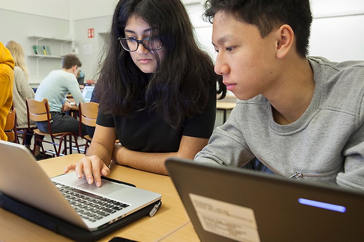 Två elever som arbetar med en bärbar dator i ett klassrum